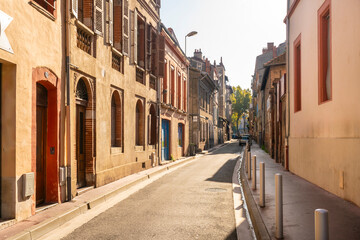 Fototapeta premium Facade or exterior of historic traditional houses in red or orange in the old city of Toulouse, France