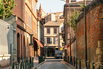 Facade or exterior of historic traditional houses in red or orange in the old city of Toulouse, France