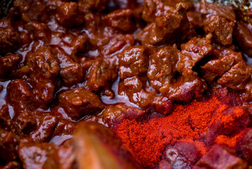 Traditional goulash soup is cooking in the a cauldron.