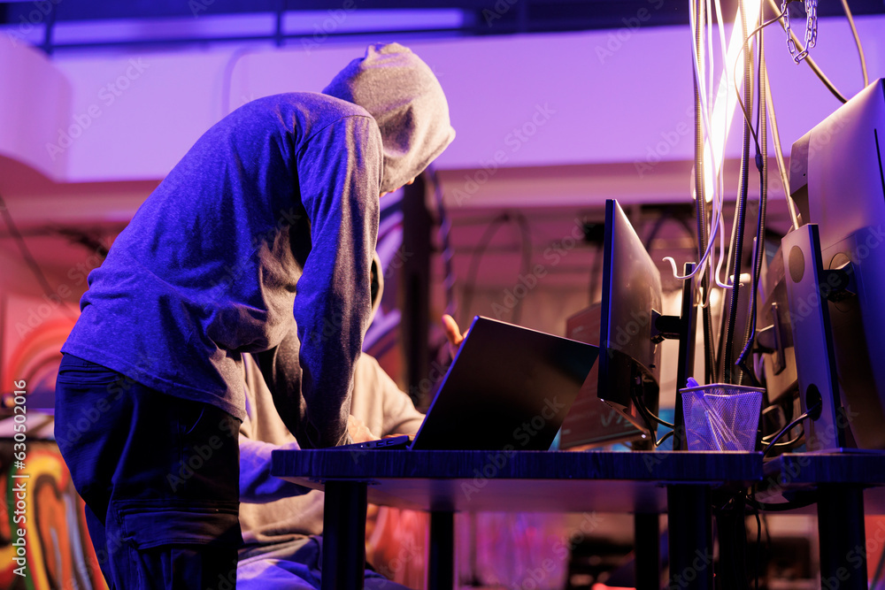 Poster hackers cracking password and getting unauthorized access to database on laptop. criminals in hoods 