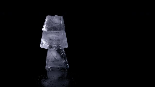 Frozen water pyramide on black background. A view of frozen water cubes like a pyramide on the black background. A concept of saving glaciers in the world.