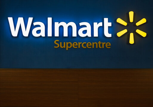 Walmart superstore exterior facade brand logo signage at night. Walmart is an American multinational retail corporation