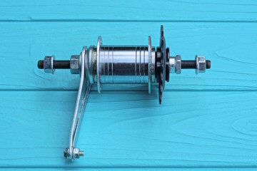 one gray black metal part of a bicycle hub for the rear wheel lies on a blue wooden table