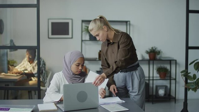 Caucasian woman working as manager disturbing and psychologically abusing her Muslim subordinate