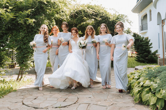 Photo of the bride and bridesmaids with wedding bouquets. Wedding day. Happy girls at their best friend's wedding. Summer wedding