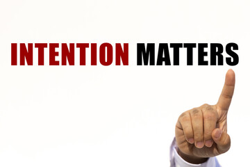Intention matters text on white wall background with businessman's finger point at the message with empty space. This message can be used as business concept about intention matters.