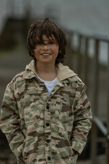 teenage  boy in a military style jacket background blur