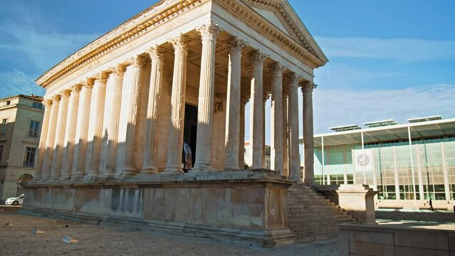The Roman temple in Nimes, Occitanie, France on a sunny summer day. Antique temple decorated with columns and friezes in France.
