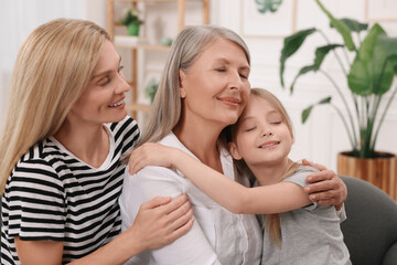 Three generations. Happy grandmother, her daughter and granddaughter at home