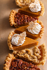 Variety of Thanksgiving pie slices on parchment paper