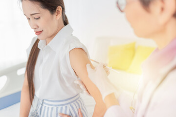 Fototapeta premium Doctor inject vaccine to woman, Deltoid muscle injection technique, immunization and health care promotion