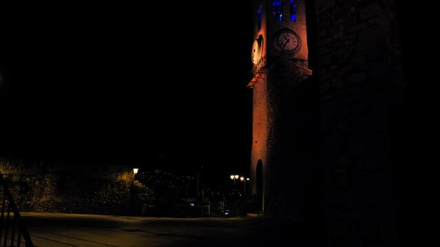 Clock and bell tower of Church of Notre Dame D'esperance at night in Cannes. Colorful famous landmark lit up at resort town on the French Riviera.