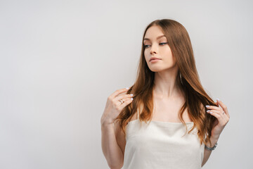 Porter of glamorous beautiful woman with healthy hair wearing nightgown isolated on gray background