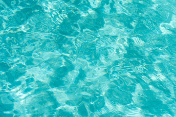 Water ripples in the swimming pool with sunlight reflection