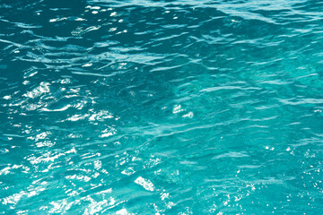 Water ripples in the swimming pool with sunlight reflection