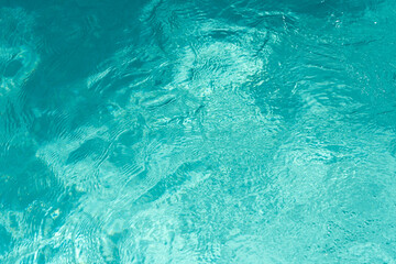 Water ripples in the swimming pool with sunlight reflection