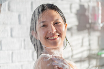 female Asian taking joy in the shower and using soap She feels at rest.