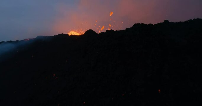 Slow motion FPV drone shot through lava at an exploding volcano caldera in Iceland