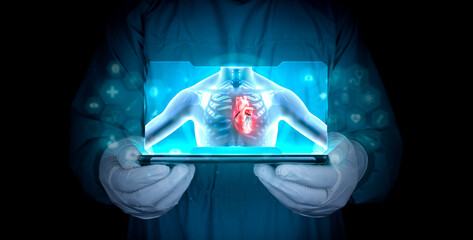 The doctor studies and analyzes the human heart. Digital window shows the x-ray of the human body....