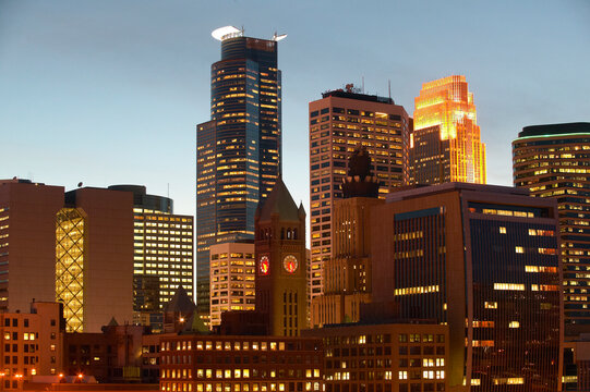 Skyline of Minneapolis Minnesota as the sun is setting over the city and the lights are on