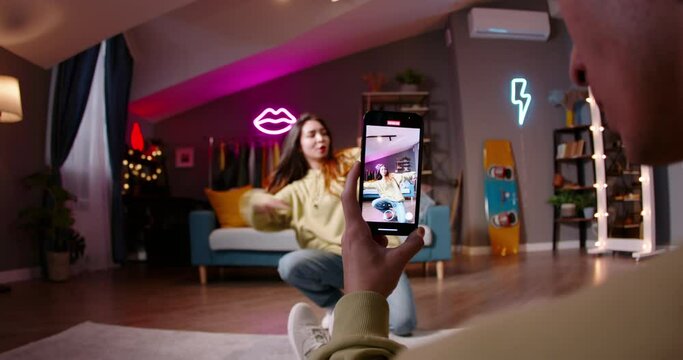 Asian female recording video of trending hip hop dance challenge for likes and followers on social media platform, vertical video. Preparation viral trend dance from talented enthusiastic blogger