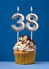 Burning candle number 38 - Birthday card with cake on blue Background
