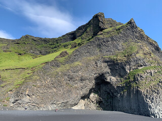 the basalt columns at Reynisfjara, the famous black beach in Iceland, near Vík í Mýrdal, form a...