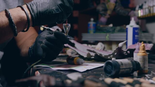 painting workshop man paints mixing paint in airbrush medium slow motion shot