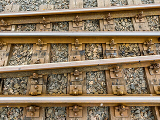 narrow gauge railway with thresholds, gravel and rusty bolts. transportation background.