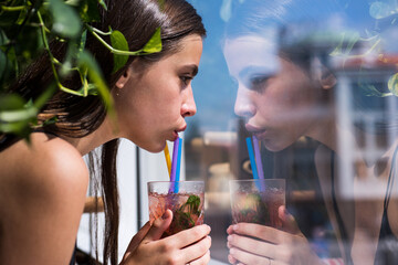 Young girl drinking a cocktail. Summer refreshment. Woman face, sexy female portrait. Beautiful...