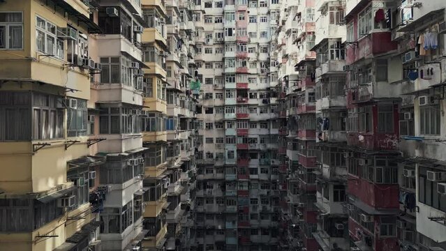 Aerial of an old apartment complex called Yick Fat on Quarry Bay, Hong Kong, China. Known also as Monster Building because it was featured in a Transformers movie. Drone dolly forward shot