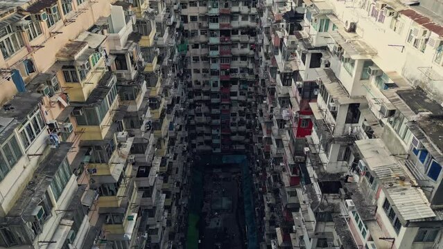 Aerial of an old apartment complex called Yick Fat on Quarry Bay, Hong Kong, China. Known also as Monster Building because it was featured in a Transformers movie. Drone dolly forward and tilt down