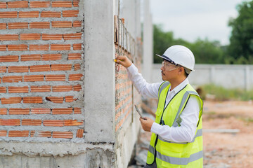 Engineer inspecting the house structure Using a tape measure to check the thickness of the pole through online technology as a helper