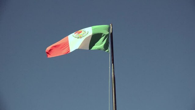 Mexican flag on pole moving in the wind