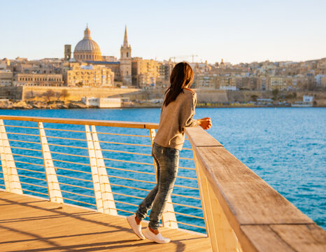 Asian women watching sunset at Valletta Malta city Skyline, colorful house balcony Malta Valletta, panoramic view over Valletta Malta old town at sunset