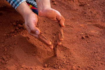 Hands cradling the soil evoke a sense of care and responsibility, representing the essential role...