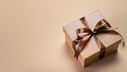 Gift box brown ribbon on beige background