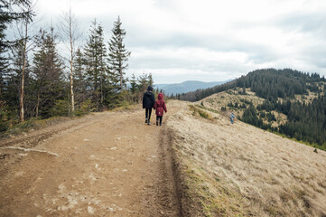Two children - son and daughter walk around the mountain ridge by the hands