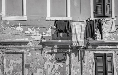 Clothes hanging on wire to dry outside, in Venice. Black and white photography