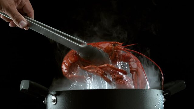 Taking boiling lobster out of pot in super slow motion.