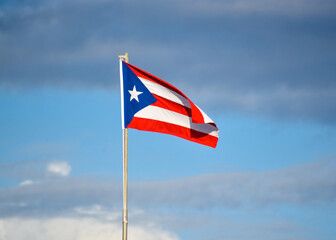 bandera de Puerto Rico ondeando en el cielo azul con nubes , primer plano - obrazy, fototapety, plakaty