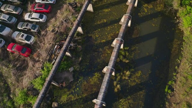 Fayetteville Express gas pipeline leading along rusting old cars and wetlands.