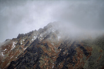 Landscape of mountain peak in low clouds.