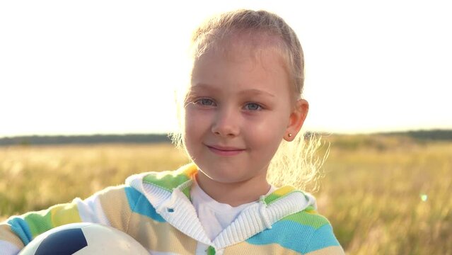 little girl plays with ball her hand, her face adorned with smile resembling small child. childhood dream soccer player, reliving joy playing playground. children engage active break, enjoying time