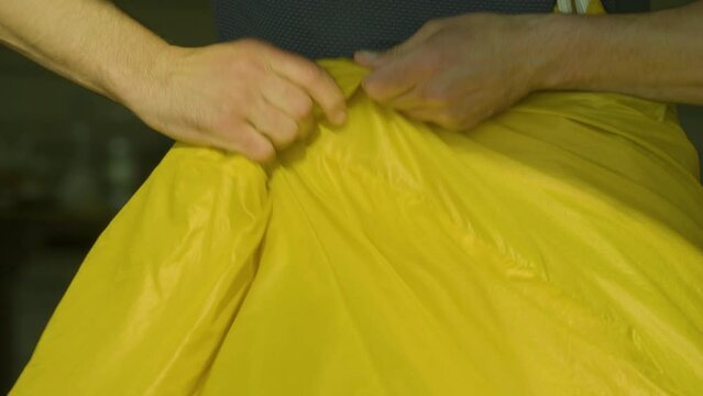 Caucasian skydiver meticulously inspects and folds parachute before dive