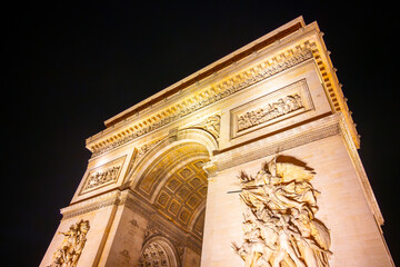 Detailed view of Arc de Triomphe from bottom by night, Paris, France