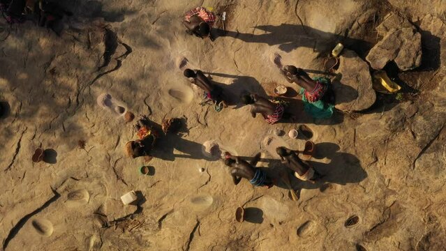 Aerial view of Larim tribe women grinding sorghum grains Imatong South Sudan