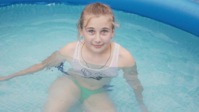 girl swims in the pool. Summer rest