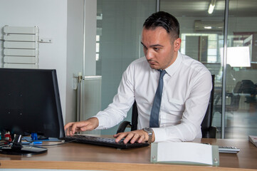 Fototapeta na wymiar Young man using laptop in office