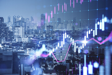 Fototapeta na wymiar Glowing candlestick forex chart on blurry city buildings background. Technology, trade and financial data concept. Double exposure.
